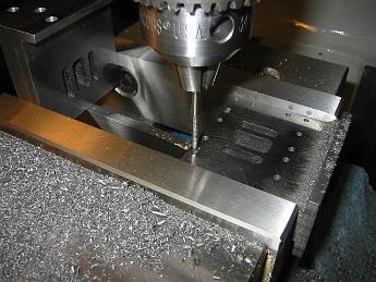  27-Feb-05  Tapping the Valve chest bolt holes.  These cast iron valve chests were machined at Joel's shop on his big Cincinati Toolmaster mill.  I could take 50 thou cutting passes on his mill, whereas on my lighter Bridgeport I only take half that amount (25 thou), so his machine saved me half the machining time.  The right equipment can make a difference!